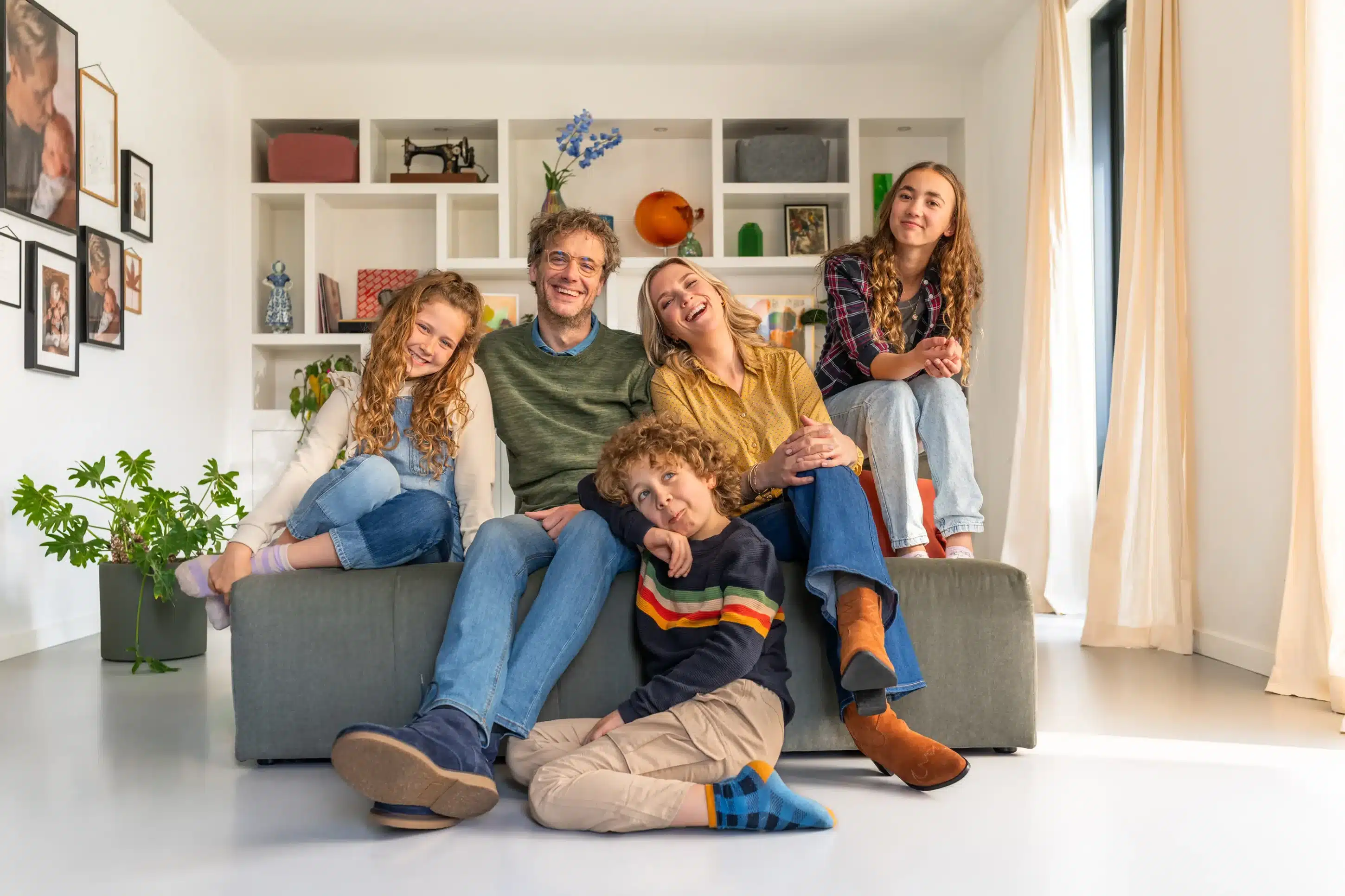 Gezin op de bank in huis voor de consumenten campagne van Hoppenbrouwers.